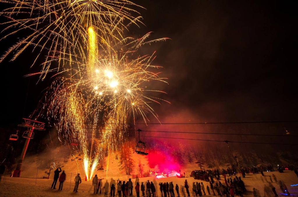 um grupo de pessoas de pé na neve assistindo fogos de artifício em Boost Your Immo Vars Le Lubéron 94 em Vars