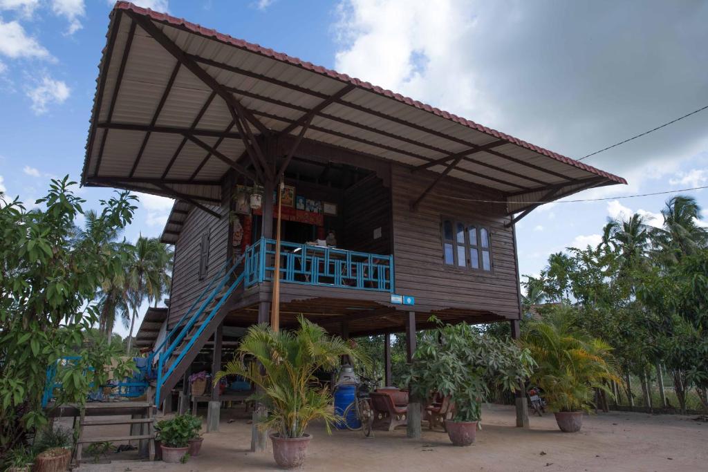 une maison avec une terrasse couverte et un balcon dans l'établissement Chansor Community Homestay 14, à Phumĭ Trach Pôk (2)