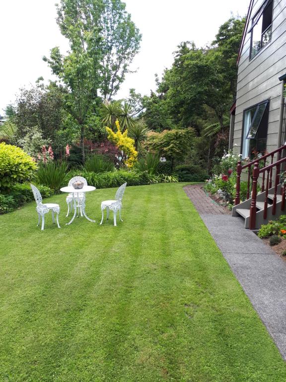 a lawn with two chairs and a table in a yard at Rangaroa Heights in Taumarunui