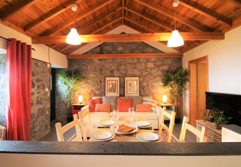 ein Esszimmer mit einem Tisch und einem Sofa in der Unterkunft Pike Cliffs I in Prainha de Cima