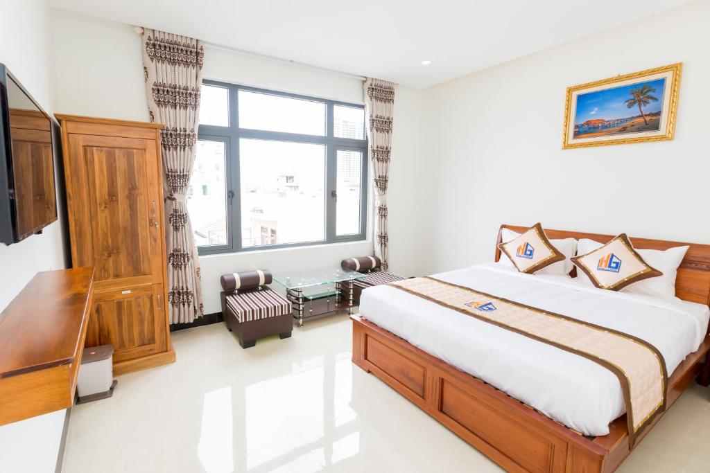 HUNG GIA HOTEL في كوي نون: غرفة نوم بسرير ونافذة كبيرة