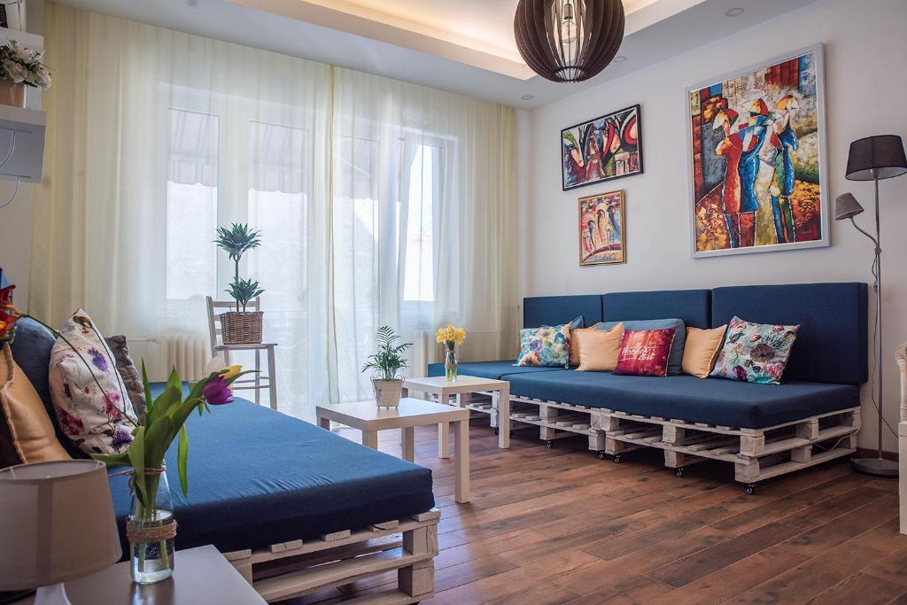 ein Wohnzimmer mit einem blauen Sofa und einem Tisch in der Unterkunft Hostel Beogradjanka in Belgrad