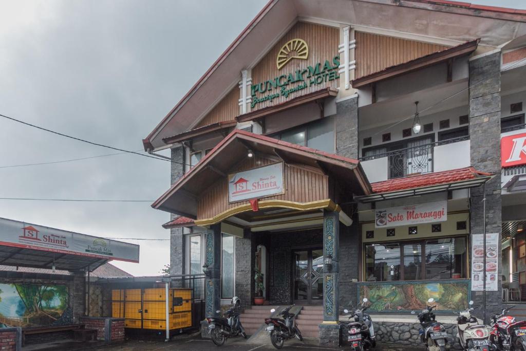 un bâtiment avec des motos garées devant lui dans l'établissement RedDoorz Syariah @ Cipanas, à Sindanglaya