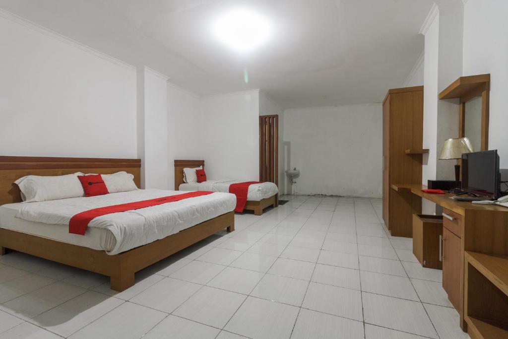 Postel nebo postele na pokoji v ubytování RedDoorz Syariah @ Cipanas