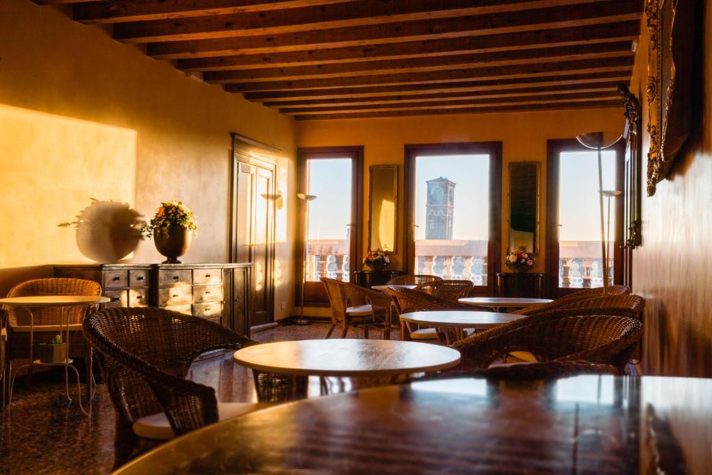 un restaurante con mesas, sillas y ventanas en Locanda Ai Santi Apostoli en Venecia
