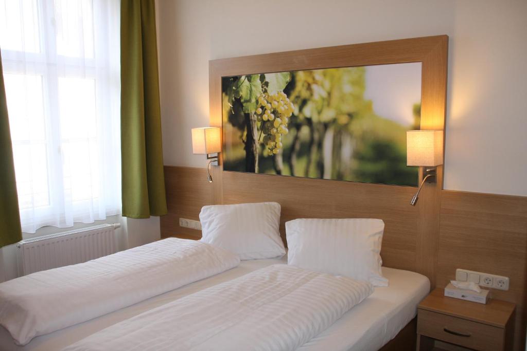 Bett in einem Schlafzimmer mit Wandgemälde in der Unterkunft Weinhotel Rieder in Poysdorf