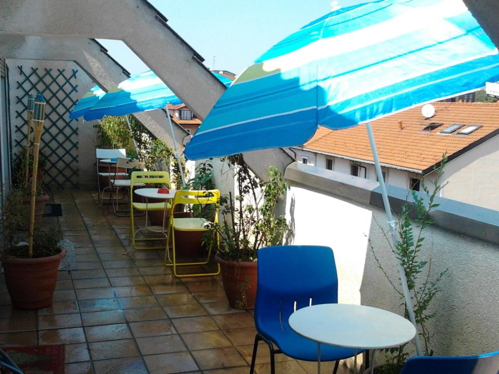 un patio con mesas, sillas y una sombrilla en Star Hostel, en Milán
