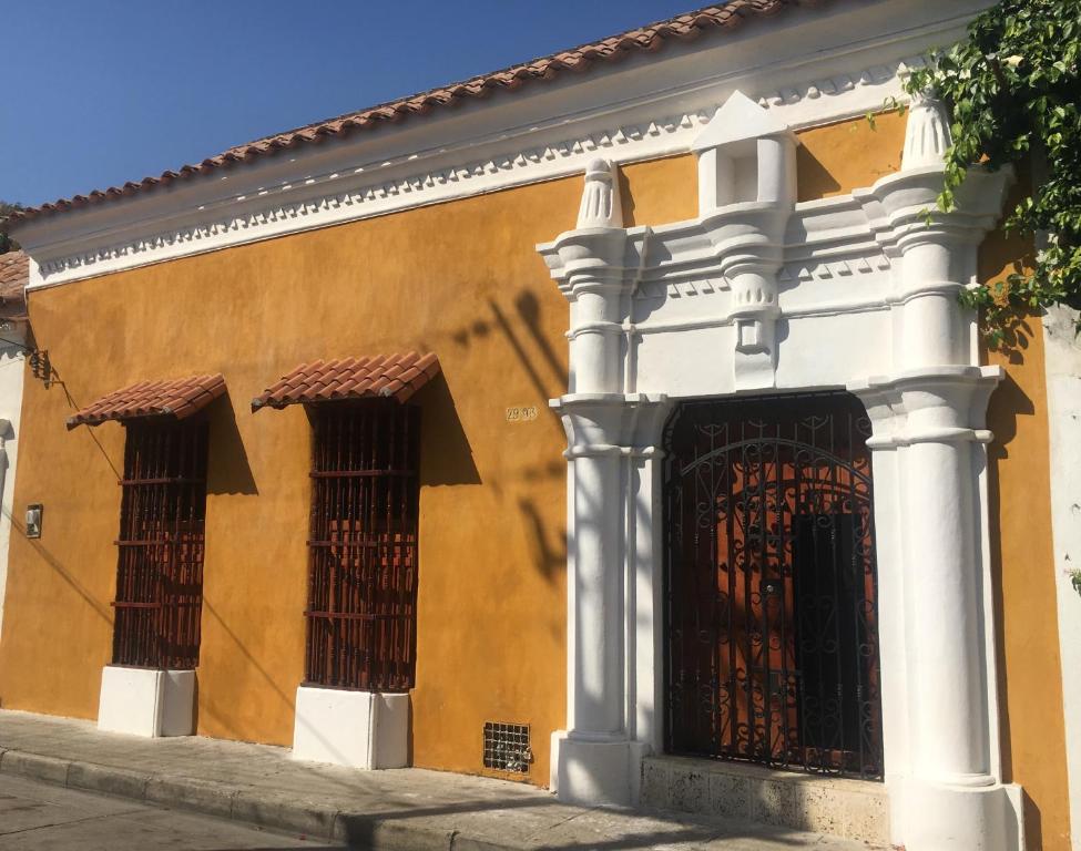 an orange building with two windows and a gate at Casa Digna in Cartagena de Indias