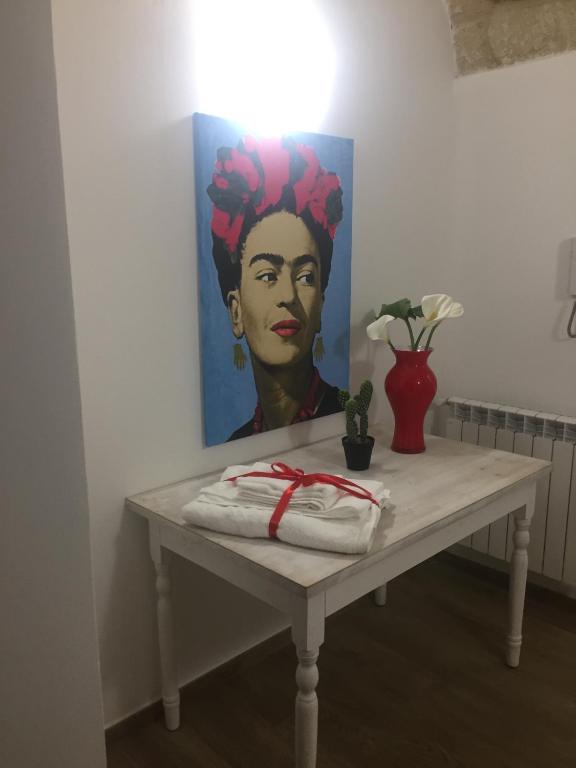 stół z obrazem kobiety z kwiatami w obiekcie Casa Vacanza La Pergola w mieście Terrasini