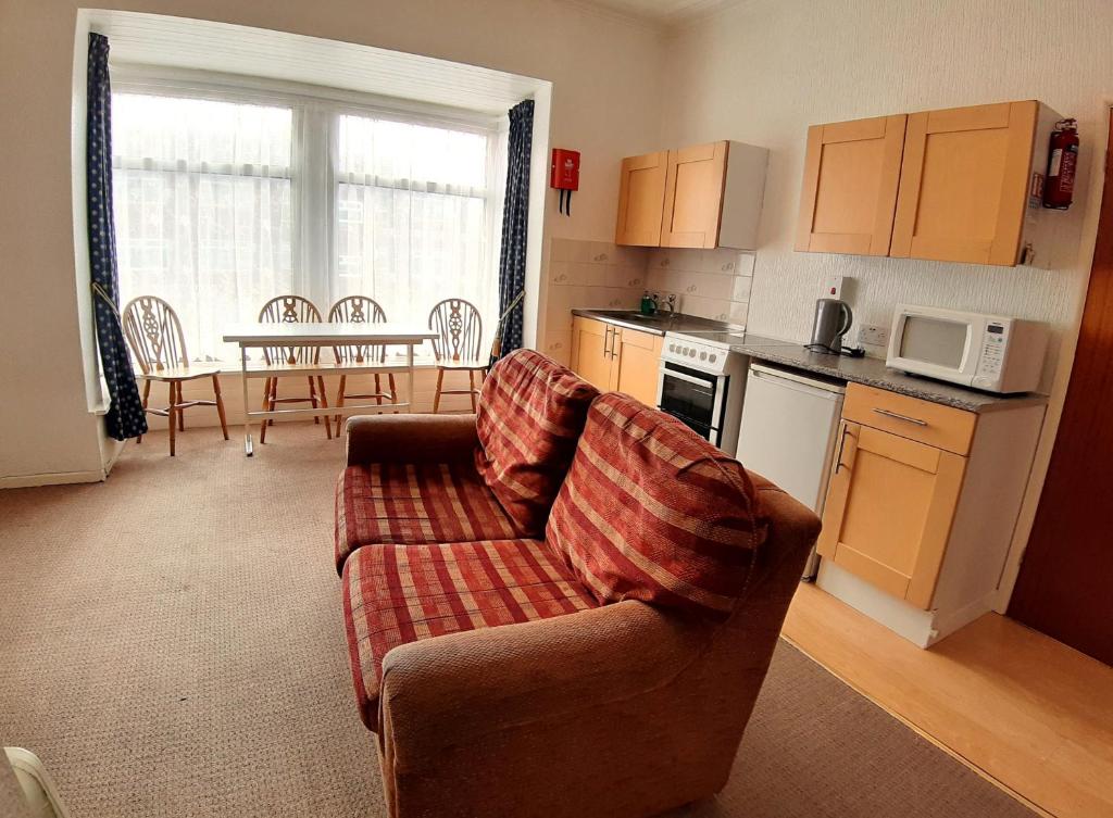 a living room with a couch and a kitchen at Rosemede Holiday Flats in Blackpool