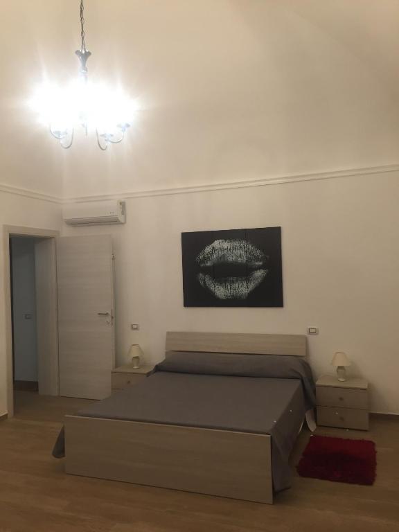 sypialnia z łóżkiem i obrazem na ścianie w obiekcie Casa Vacanza La Pergola w mieście Terrasini