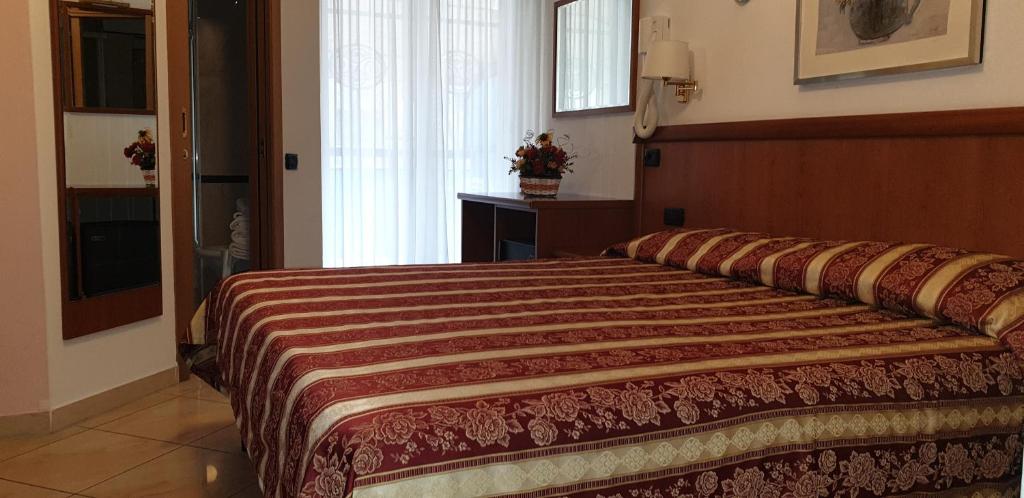 a bedroom with a large bed in a room at Hotel Ginevra in Riccione
