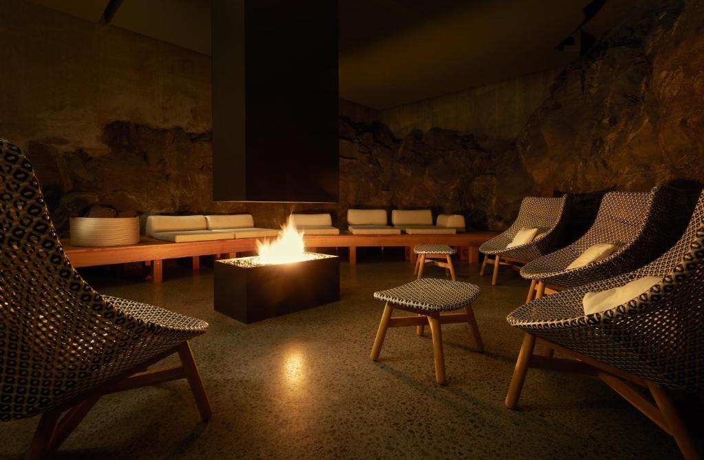 a room with chairs and a fire in the middle at The Retreat at Blue Lagoon Iceland in Grindavík