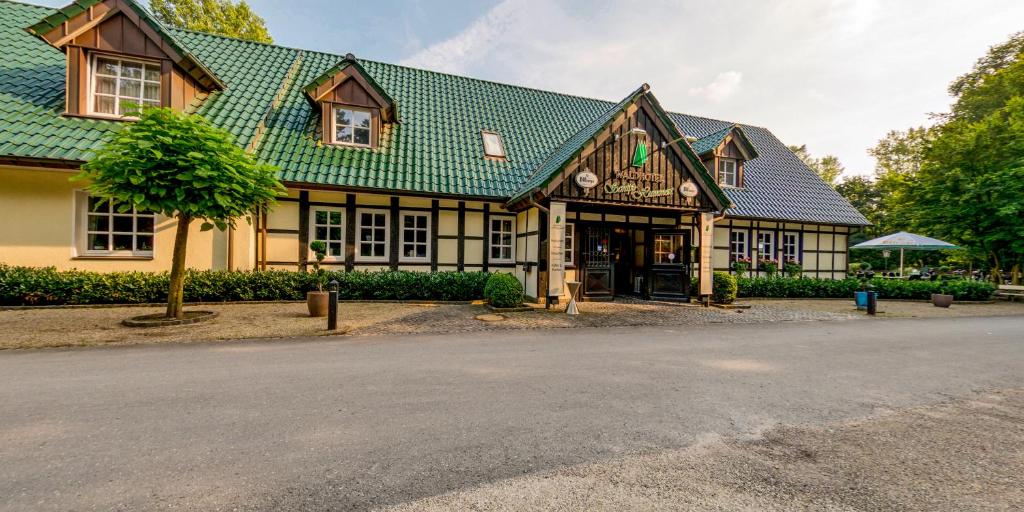 ein großes Gebäude mit grünem Dach in der Unterkunft Waldhotel Schipp-Hummert in Emsdetten