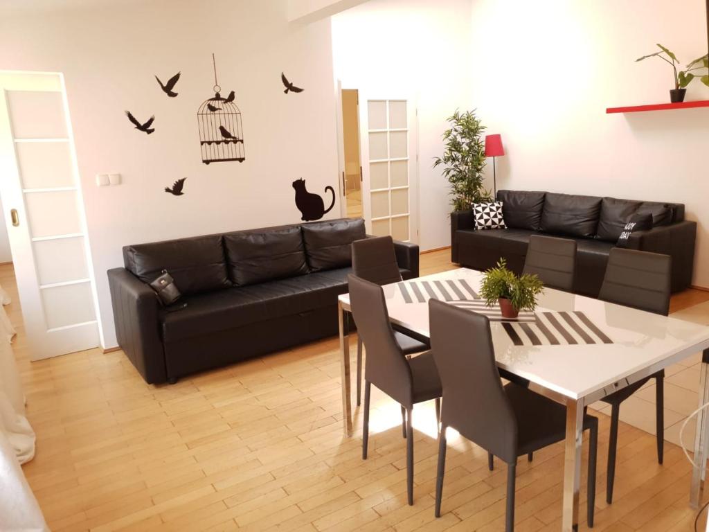 a living room with a black couch and a table at Aparthotel Old City in Krakow