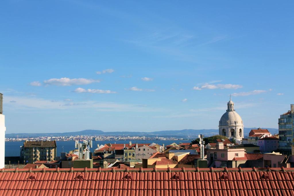 uma vista para uma cidade a partir do telhado de um edifício em Sunny 3BDR Apartment in Graça by LovelyStay em Lisboa