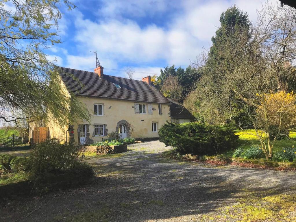 a large white house with a driveway at La Bichurie in Feugères