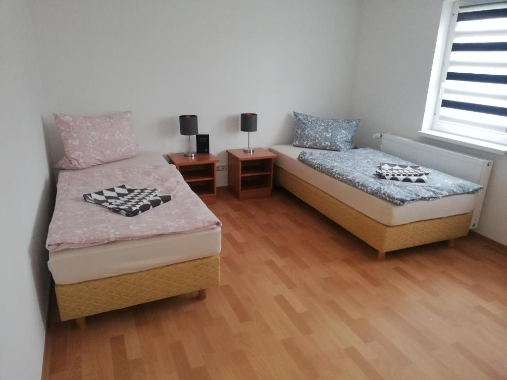 sypialnia z 2 łóżkami pojedynczymi i oknem w obiekcie Pension Mathias Heilmann w mieście Aschersleben