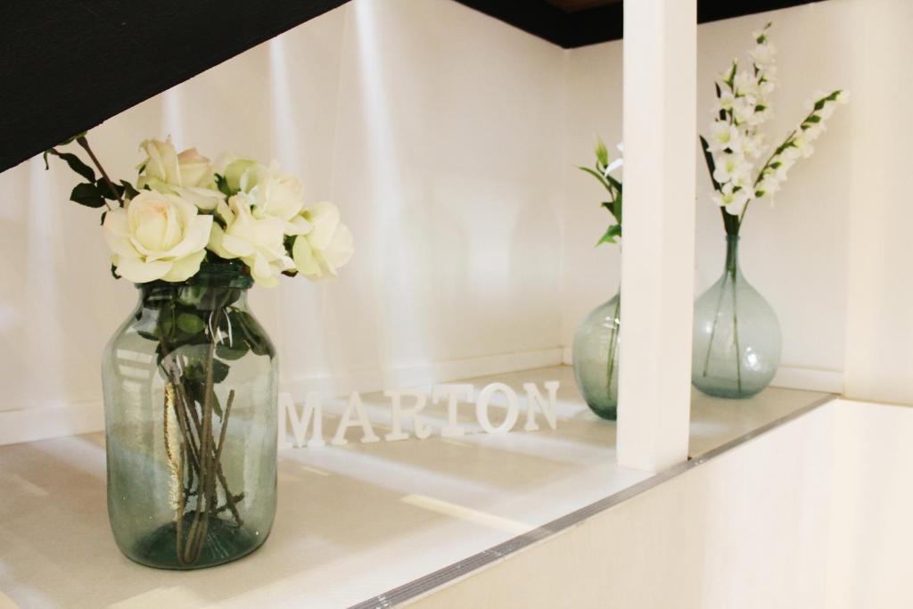 three vases with flowers sitting on a shelf at Marton Hotel Valldemossa in Valldemossa