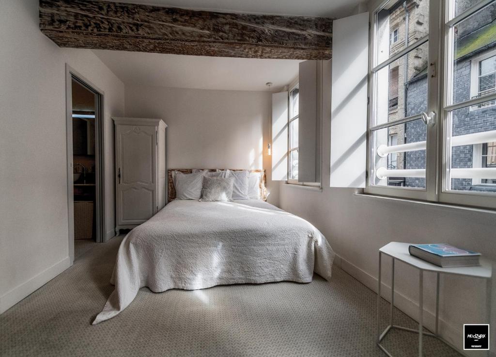 a bedroom with a white bed and a window at Ma Poésie - Charme & emplacement idéal in Honfleur