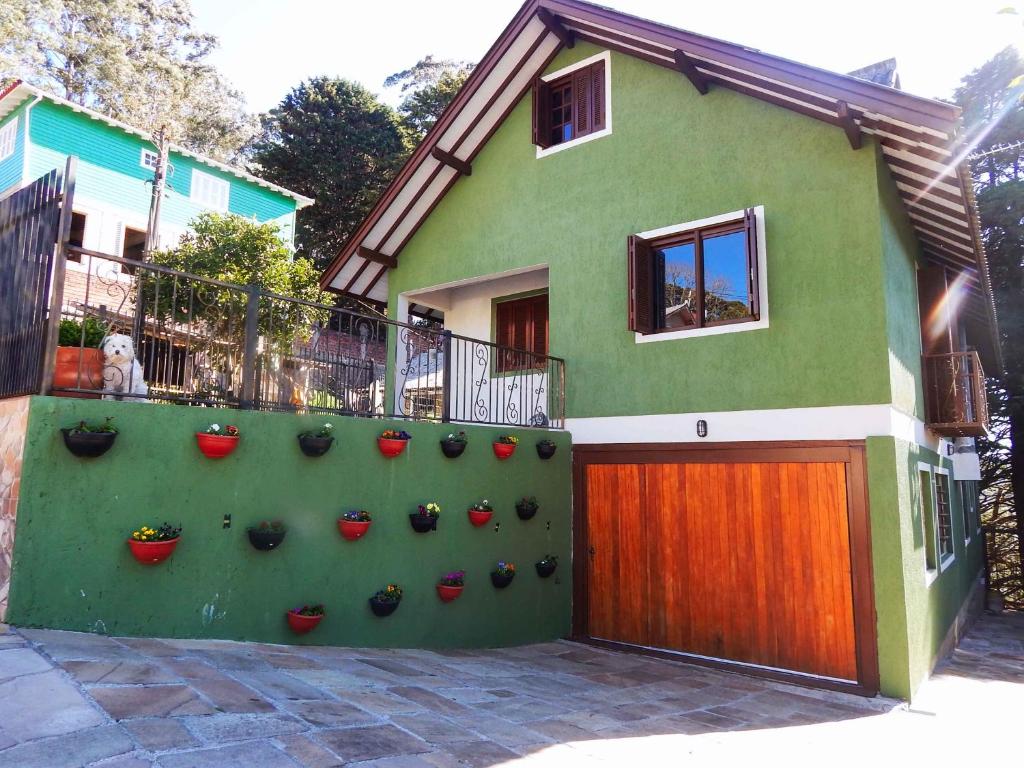 una casa con una pared de plantas delante de ella en Gramado Suites Residence possui 5 quartos e 5 banheiros, en Gramado