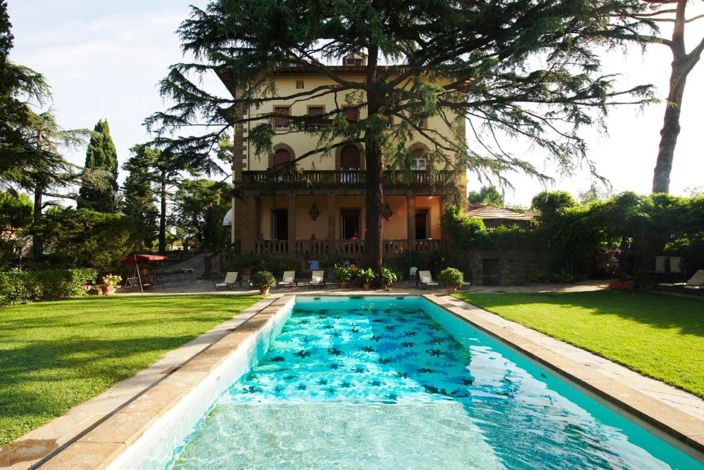 a house with a swimming pool in front of a house at Park Palace Hotel in Florence