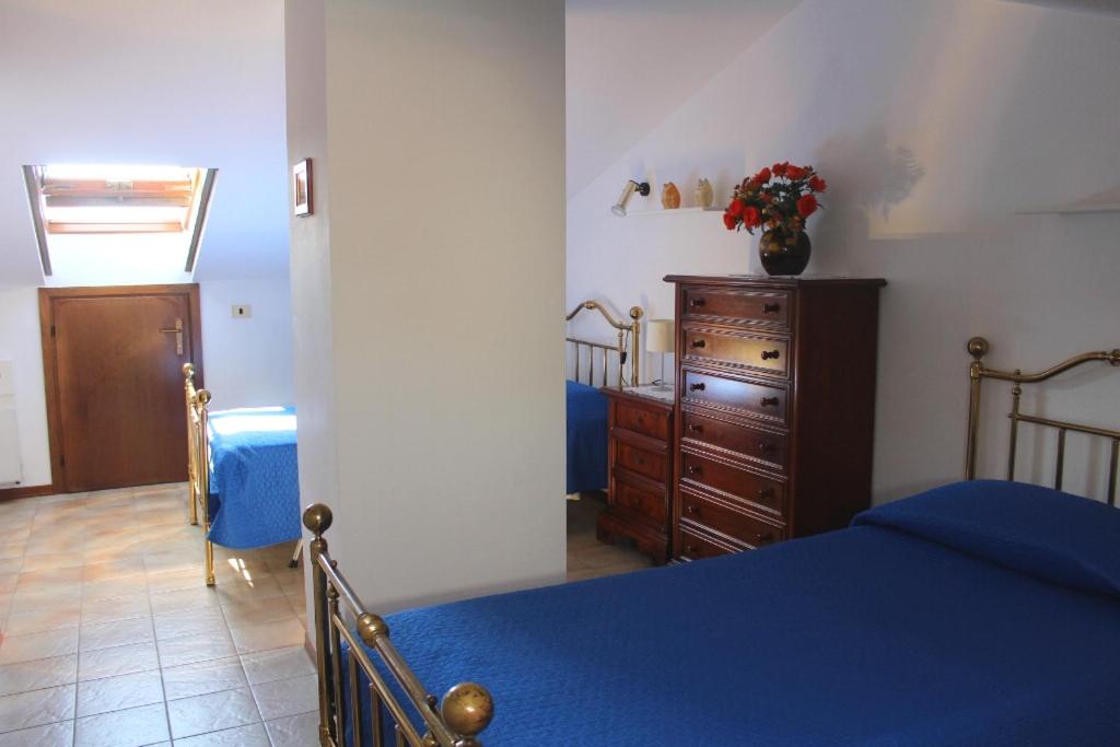 トッリ・デル・ベーナコにあるResidenza Riviera degli Oliviのベッドルーム(青いベッド1台、木製ドレッサー付)