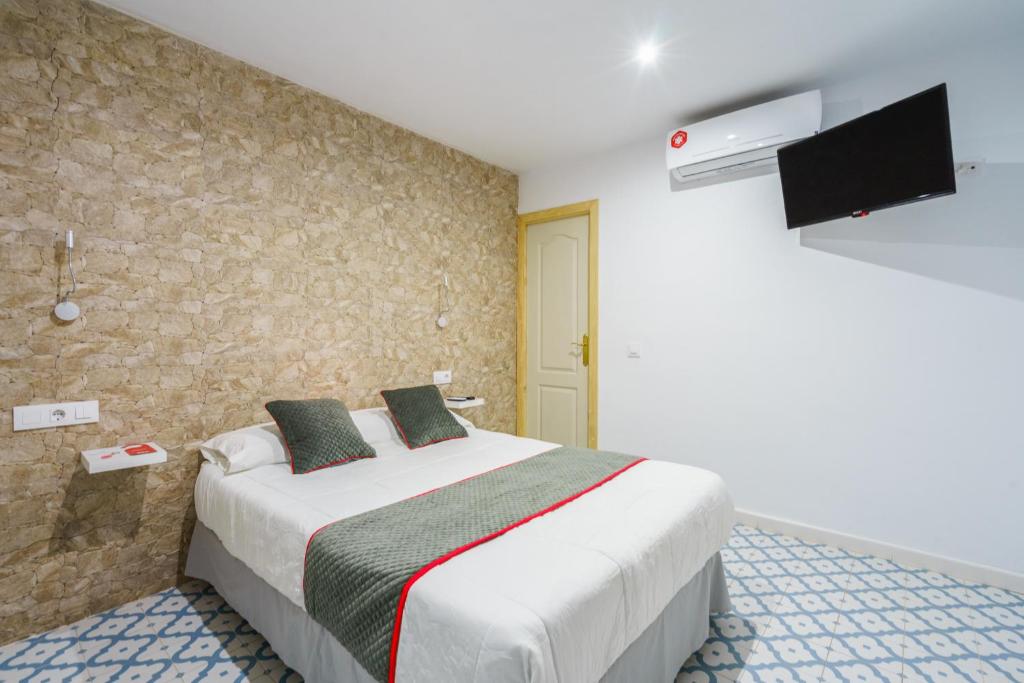 
A bed or beds in a room at Pensión Riad Mediterraneo
