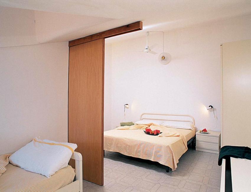 una camera con due letti e frutta di Residence La Playa a Scalea