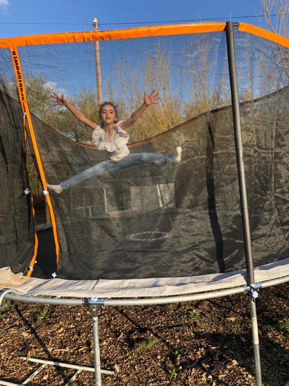 a woman jumping on top of a trampoline at Willow Court Farm Studio East & Petting Farm, 8 mins to Legoland & Windsor, 15 mins to Lapland UK in Windsor