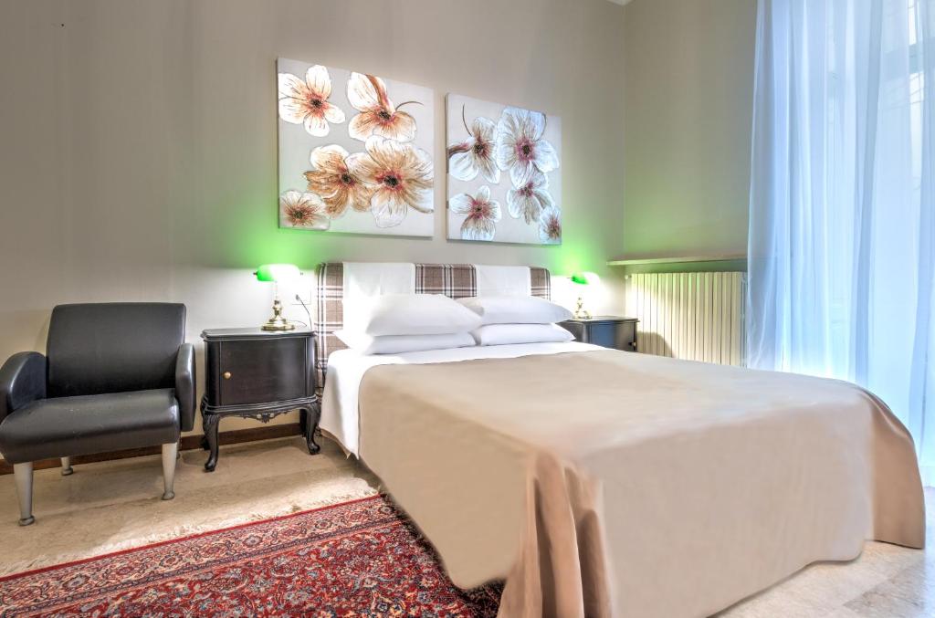 1 dormitorio con 1 cama blanca grande y 1 silla en Ramé Suites, en Bérgamo