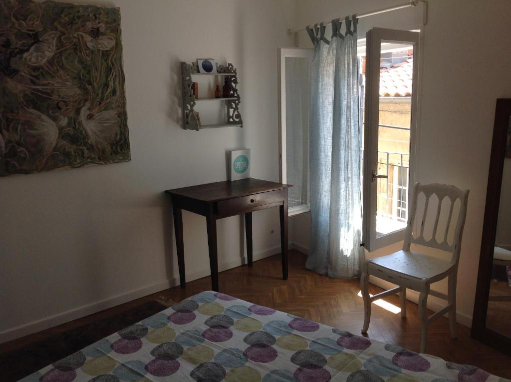 une chambre avec un lit, un bureau et une chaise dans l'établissement Appartement centre historique Beziers, à Béziers