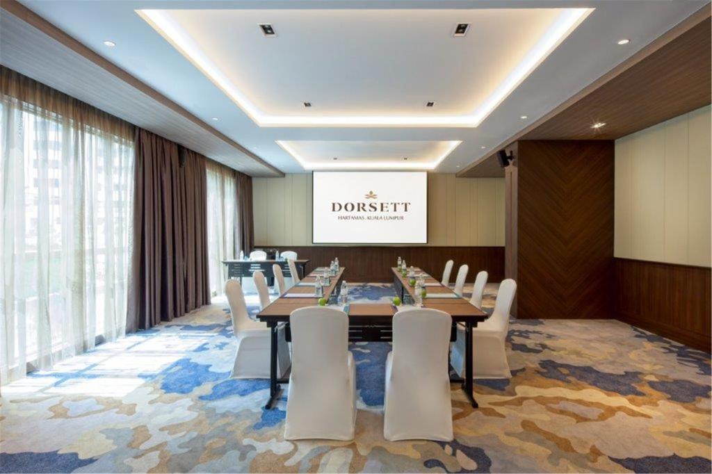 A bright conference room arranged around a long meeting table.