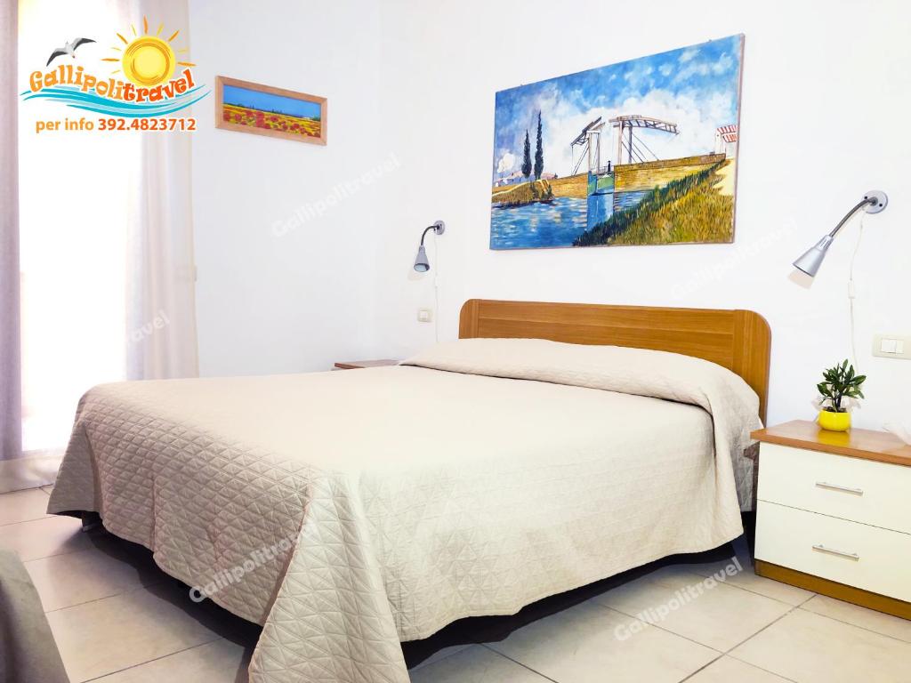 ガリポリにあるGallipolitravel Residence Baia Verdeのベッドルーム1室(ベッド1台付)が備わります。壁には絵画が飾られています。