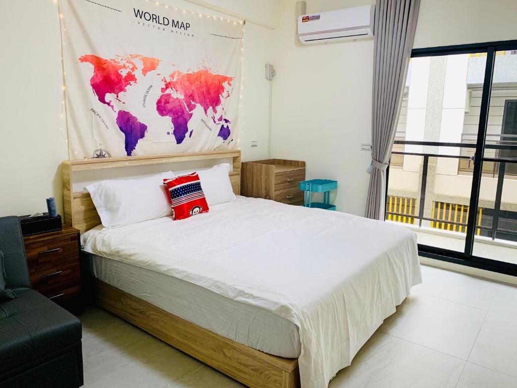 礁溪鄉的住宿－美家民宿，卧室配有一张大床,墙上挂有地图
