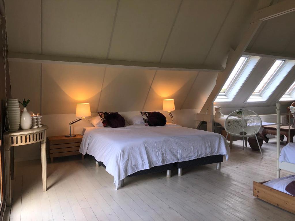 a bedroom with a large white bed with skylights at Vitamine D in Koksijde