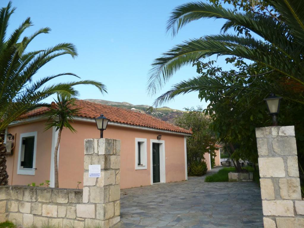 a house with palm trees in front of a street at Pantelios Village in Katelios