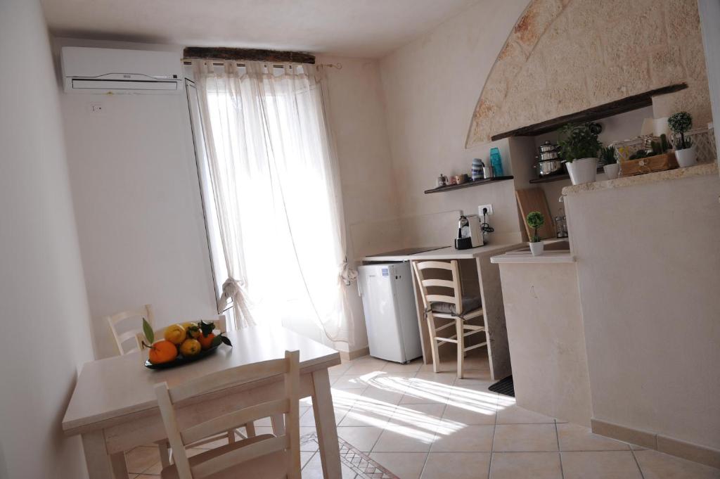 een keuken met een tafel en een keuken met een raam bij Apulianstay-Dimora Pace in Monopoli