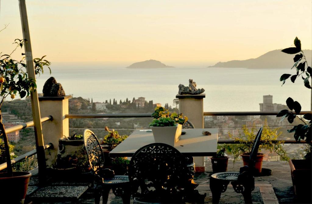 a table on a balcony with a view of the ocean at IL golfo artisti e poeti villa thea in Lerici