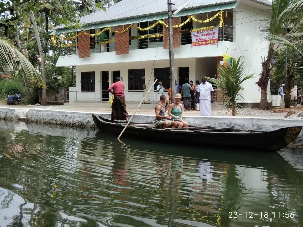 a couple of people in a boat in the water at Royal Munroe Palace Home Stay in Munroe Island