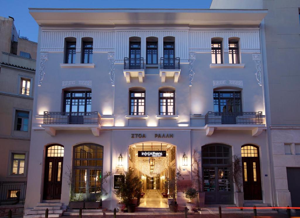 a large white building with a lit up doorway at InnAthens in Athens