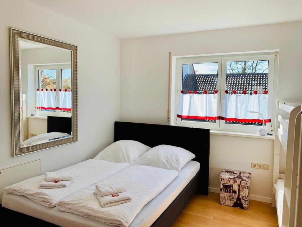 1 dormitorio con 1 cama grande y espejo en Ferienwohnung Eichel, en Rust