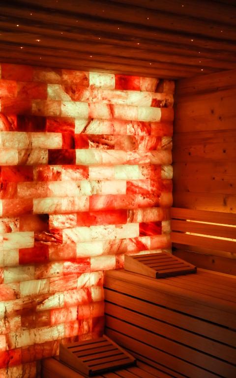 un mur en pierre avec deux bancs dans un sauna dans l&#39;établissement Hôtel Restaurant Spa Les Jardins De Sophie, à Xonrupt-Longemer