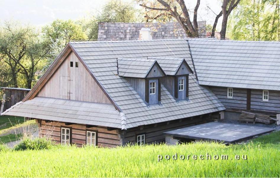 a wooden house with a roof on a field at Drevenica pod orechom in Detva