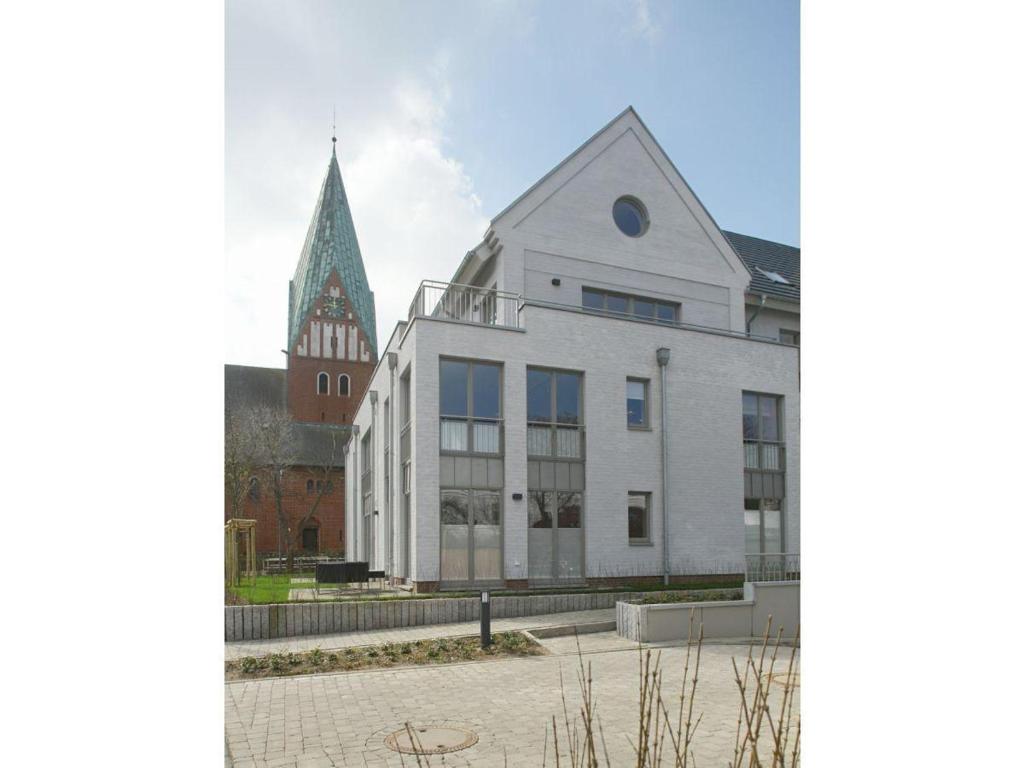 um grande edifício branco com uma igreja ao fundo em Victoriaresidenz-App-12-Ekki-s-Suite em Westerland