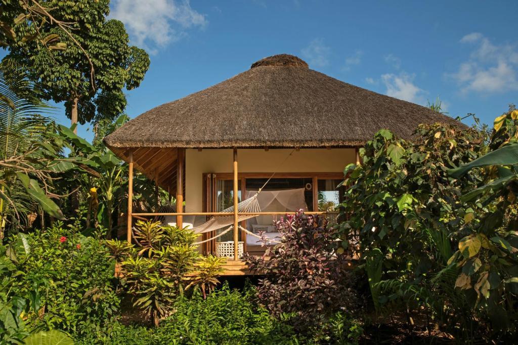 a gazebo with a straw roof in a garden at Zuri Zanzibar in Kendwa