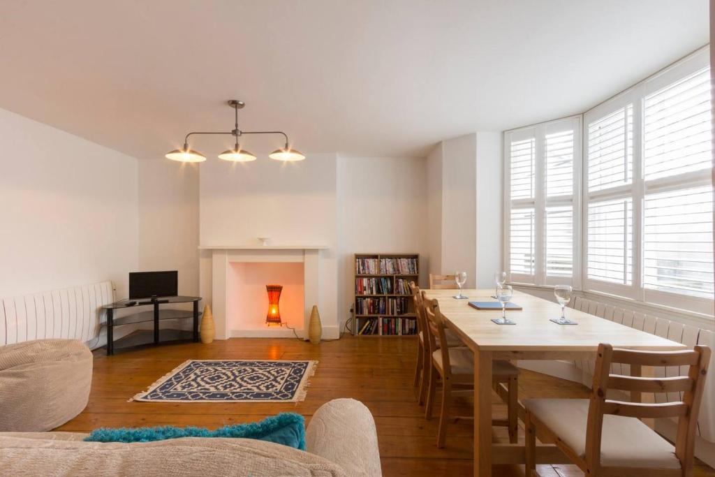 a living room with a table and chairs and a fireplace at Host & Stay - Victoria Gardens in Ramsgate