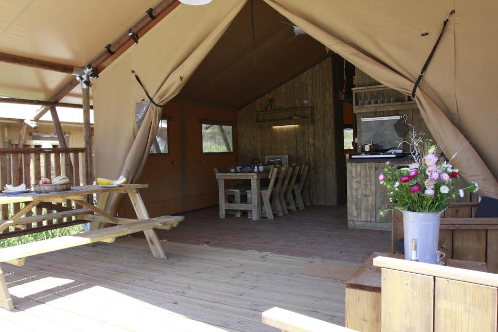 a tent with a table and chairs in it at Glamping Alcantara in Motta Camastra