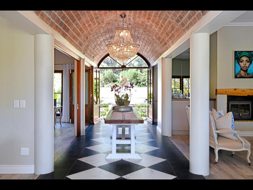 a dining room with a table and a chandelier at Huguenot House in Franschhoek