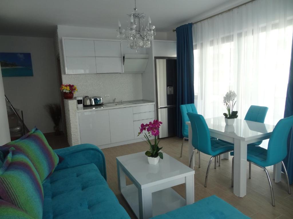 uma sala de estar com um sofá azul e uma mesa em Sophia Residence em Mamaia